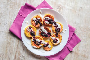 Bir plaka üzerinde ekşi krem ve reçel ile Curd peynir kek, krep