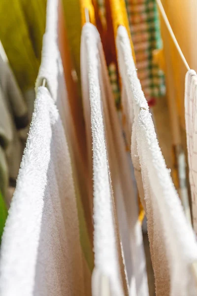 Wit en gekleurd linnen en handdoeken worden gedroogd op de clotheslin — Stockfoto