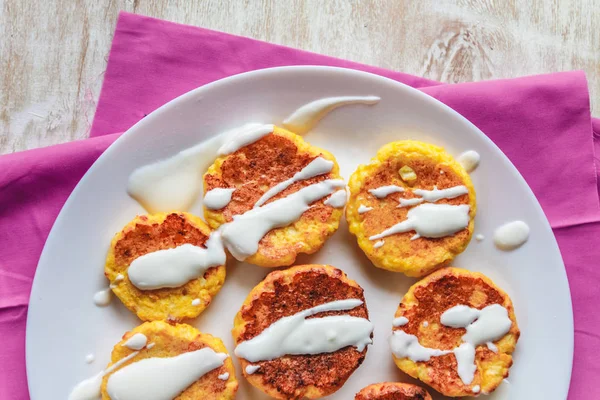 Torte di formaggio di cagliata, frittelle con crema aspra su un piatto e un ligh — Foto Stock