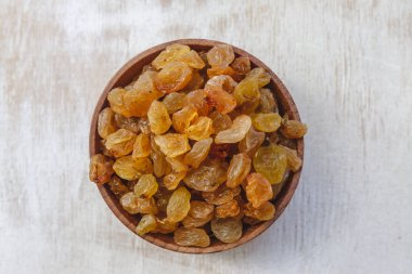 Açık beyaz backgroun ahşap bir kase açık sarı kuru üzüm