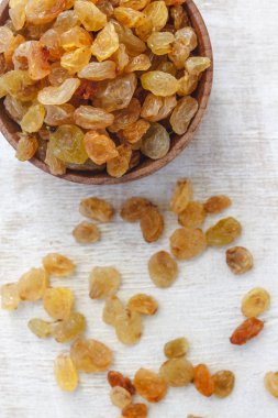 Açık beyaz backgroun ahşap bir kase açık sarı kuru üzüm