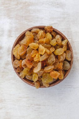 Açık beyaz backgroun ahşap bir kase açık sarı kuru üzüm