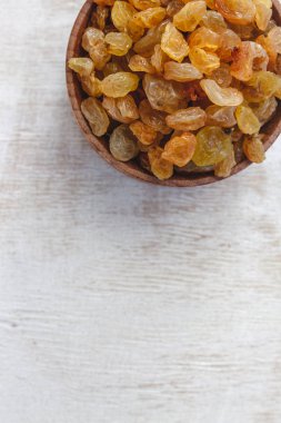 Açık beyaz backgroun ahşap bir kase açık sarı kuru üzüm