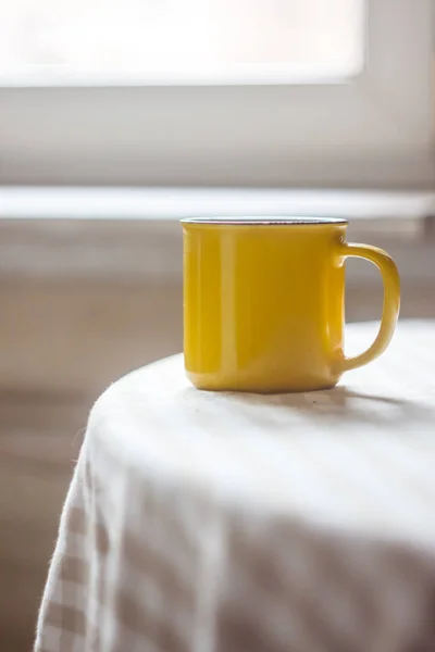 Kahve çay sarı bir fincan güneşli parlak bir masada duruyor — Stok fotoğraf