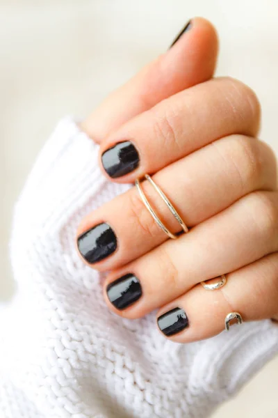 kısa nai üzerinde falankslar üzerinde siyah manikür ve halkalar ile el