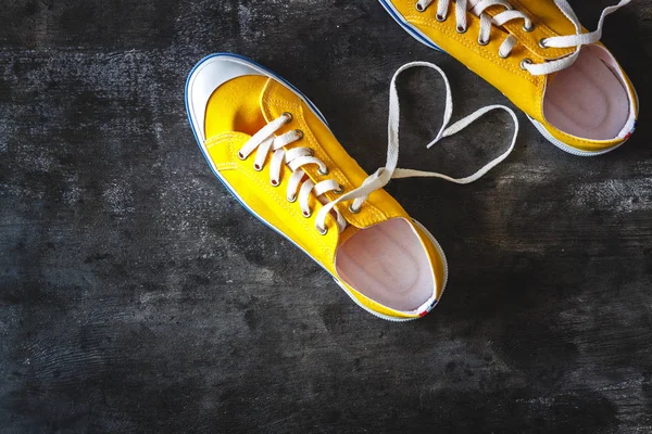 Yellow-orange sneakers on a grunge concrete dark background and