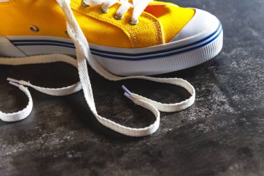 Sarı-turuncu spor ayakkabı bir grunge beton koyu arka plan ve 