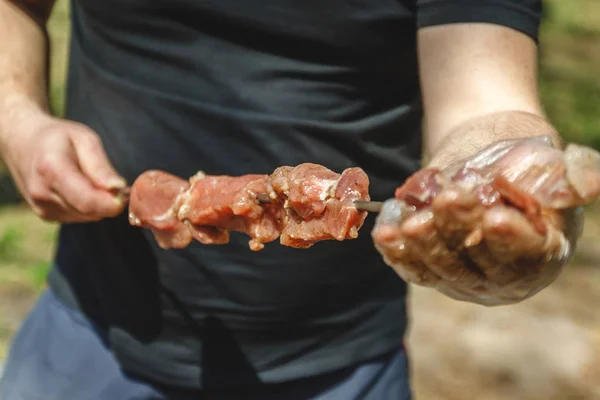Man stringing meat on a skewer. Close-up. — Stock Photo, Image