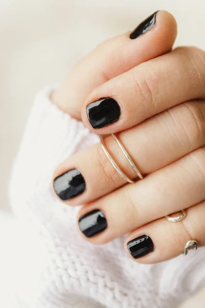 Hand met zwarte manicure en ringen op de falangen op korte Nai — Stockfoto