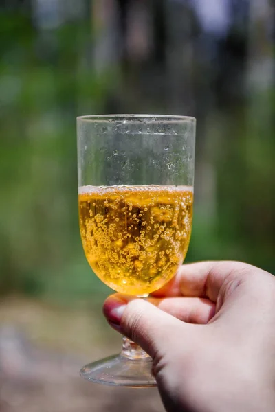 In zijn hand een wijn glas met cider-Aperol in het zonlicht weer — Stockfoto