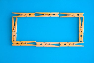 blu üzerinde ahşap clothespins yapılmış yuvarlak veya dikdörtgen çerçeve