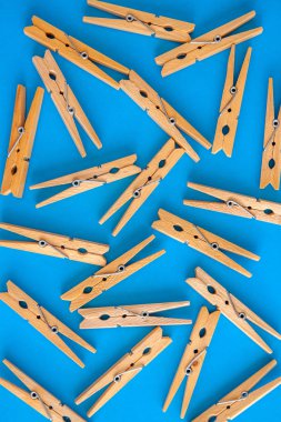 Ahşap sarı clothespins bir siyan mavisi backgroun üzerine dağınık