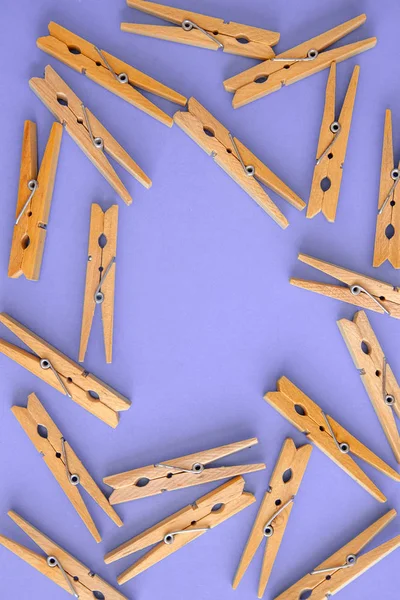 Achtergrond en frame van houten gele wasknijpers op Lila-purpl — Stockfoto