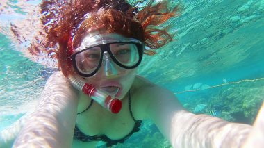 Genç kadın kız selfie yapıyor, altında kendi fotoğraflarını çekiyor