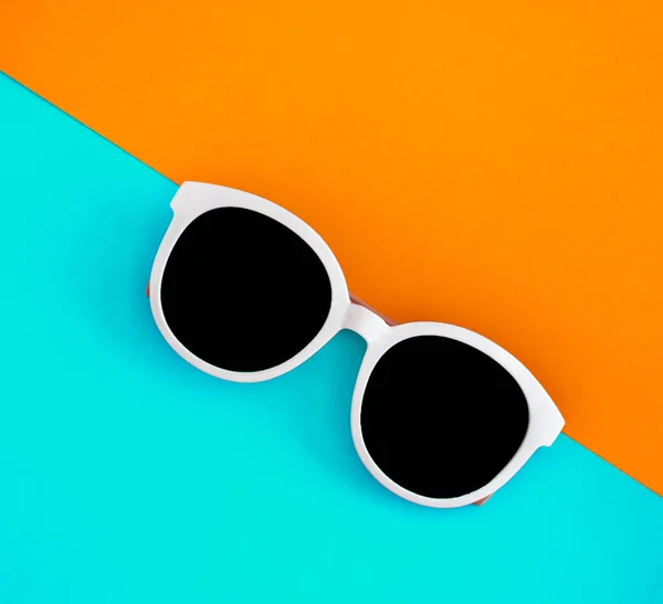 Słoneczne stylowe białe okulary przeciwsłoneczne na jasnym niebiesko-błękitnym i żółtym- — Zdjęcie stockowe