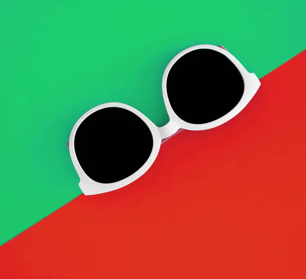 Sonnig stylische weiße Sonnenbrille auf einem leuchtend grün-cyan und rot-or — Stockfoto