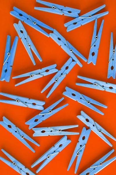 Wooden red clothespins are scattered on a blue-cyan-green backgr — Stock Photo, Image