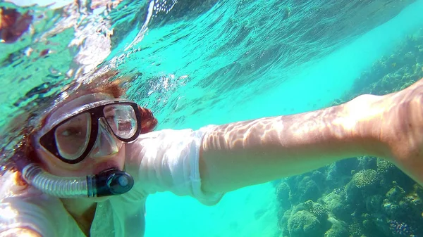 Menina jovem faz selfie, tira fotos de si mesma sob w — Fotografia de Stock