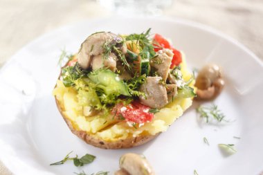 Mantar, domates ve sebze ile pişmiş patates. Açık bir rustik kumaş arka planda beyaz bir plaka üzerinde hizmet vermektedir. Close. Üst görünüm. Boşluk Kopyala.