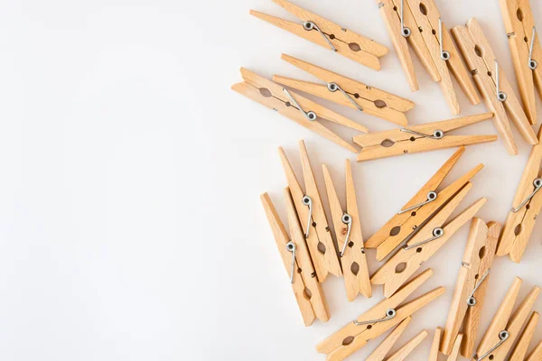 Houten wasknijpers verspreid over een witte achtergrond. Zicht van bovenaf. Kopieerruimte — Stockfoto