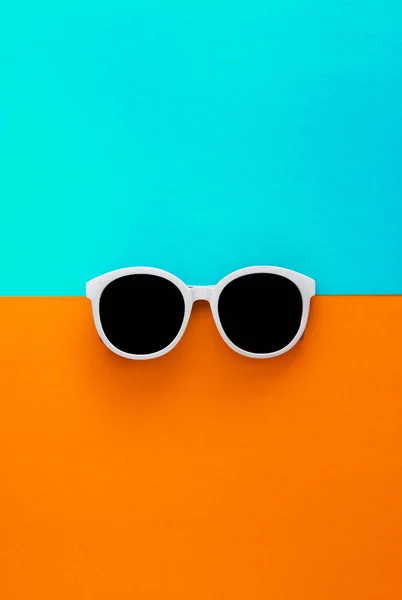 Gafas de sol blancas con estilo soleado sobre un fondo azul-cian y amarillo-naranja brillante, vista superior, aisladas. Copiar espacio. Puesta plana — Foto de Stock