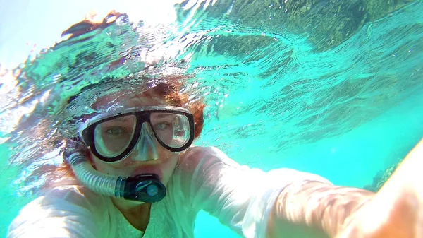 Young woman girl makes selfie, takes pictures of herself under water in the sea, near the coral reefs — Stock Photo, Image