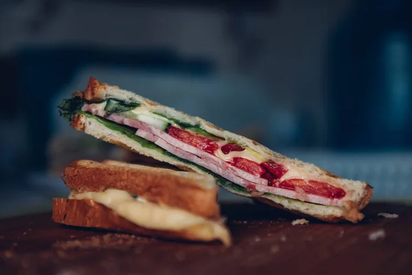 Ahşap arka planda iki sandviç, üst görünüm. Bir kesme tahtasında jambon, peynir ve marul sandviç ile Panini yığını — Stok fotoğraf