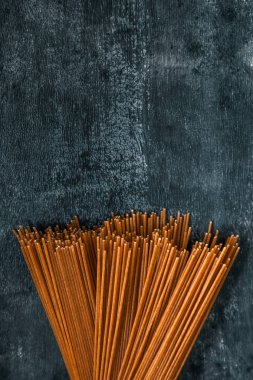 karanlık bir arka planda bir topuz ham tam tahıllı spagetti. Yukarıdan görüntüle