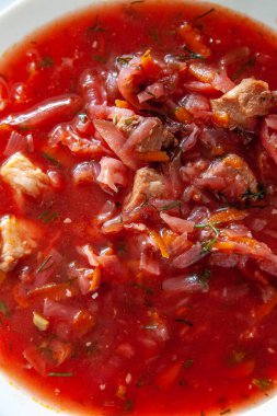 masada beyaz bir tabakta ekşi krema ile geleneksel Ukrayna-Rus domates borscht çorbası. Yukarıdan görüntüle.