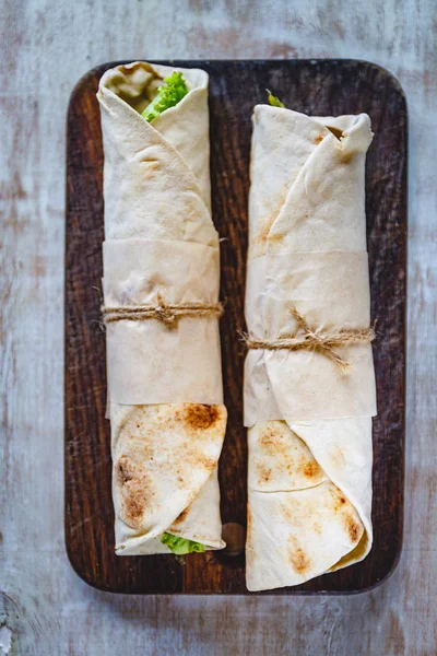 Rollos de lavash con carne, verduras y queso servidos con verde. Ensalada de lechuga sobre mesa rústica de madera. Concepto de desayuno saludable. Comida tradicional griega - Gyro —  Fotos de Stock