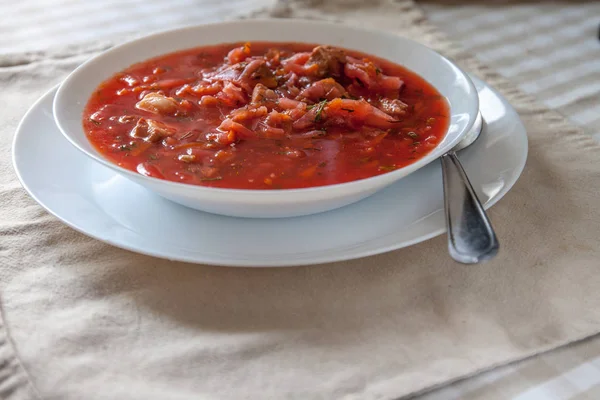 Masada beyaz bir tabakta ekşi krema ile geleneksel Ukrayna-Rus domates borscht çorbası. Yukarıdan görüntüle. — Stok fotoğraf