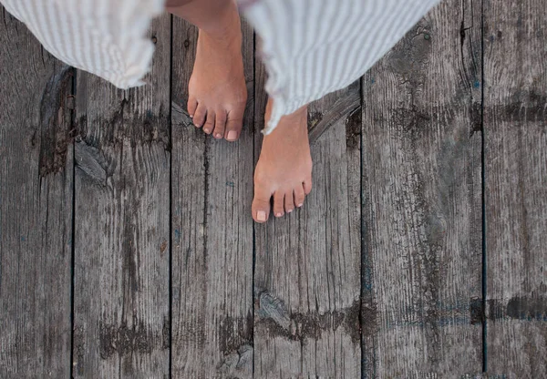 Belle femelle pieds nus bronzés avec pédicure rose sur plancher de plage en bois. Vue du dessus, espace de copie — Photo