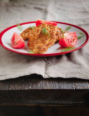 sulu et-tavuk pirzola ve basit bir hafif keten arka plan üzerinde beyaz bir tabak üzerinde domates çatal ve bıçak ile servis