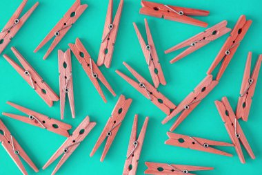 Ahşap kırmızı clothespins mavi-Camgöbeği-Yeşil arka planda dağılmış. Clothespins çerçevesi. Yukarıdan görüntüle. Boşluk Kopyala. Düz yatıyordu. Konsept doğal, çevre dostu
