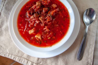 masada beyaz bir tabakta ekşi krema ile geleneksel Ukrayna-Rus domates borscht çorbası. Yukarıdan görüntüle.