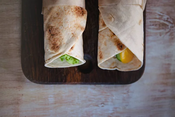 Rollos de lavash con carne, verduras y queso servidos con verde. Ensalada de lechuga sobre mesa rústica de madera. Concepto de desayuno saludable. Comida tradicional griega - Gyro —  Fotos de Stock