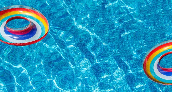 Inflatable water activities two circles tuba float on the water in the pool. banner.Concept, fun, perky summer and relaxation.