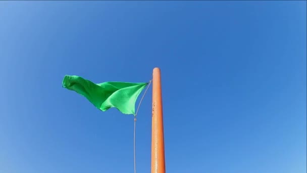 Bandeira Segura Verde Acenando Mastro Bandeira Contra Céu Azul Claro — Vídeo de Stock