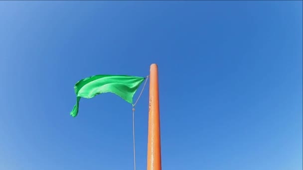 Bandera Verde Segura Ondeando Asta Bandera Contra Cielo Azul Claro — Vídeo de stock