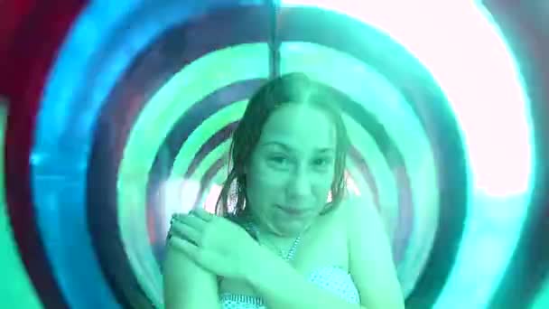 Молодая Счастливая Белая Женщина Едет Полосатой Зеленой Трубе Водной Горки — стоковое видео