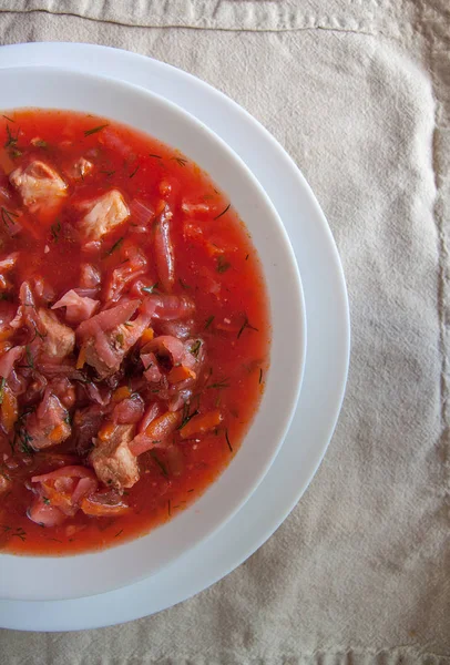 Sup borscht tomat Ukraina-Rusia tradisional dengan krim asam di piring putih di atas meja. Lihat dari atas . — Stok Foto