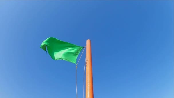 Зеленый Безопасный Флаг Размахивающий Флагштоком Против Голубого Ясного Неба Медлительность — стоковое видео
