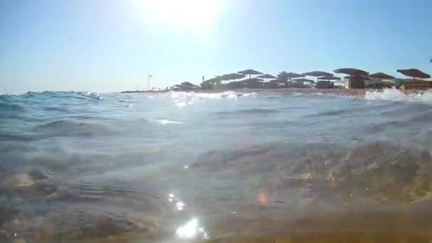 Ljusvågor Surfa Surfa Sandstranden Med Halmtak Parasoller Klar Solig Dag — Stockvideo