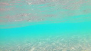 Açık güneşli bir günde kumlu kıyıya yakın ışık dalgaları, Kızıldeniz, kumlu alt. Yavaş çekim Standart hareket