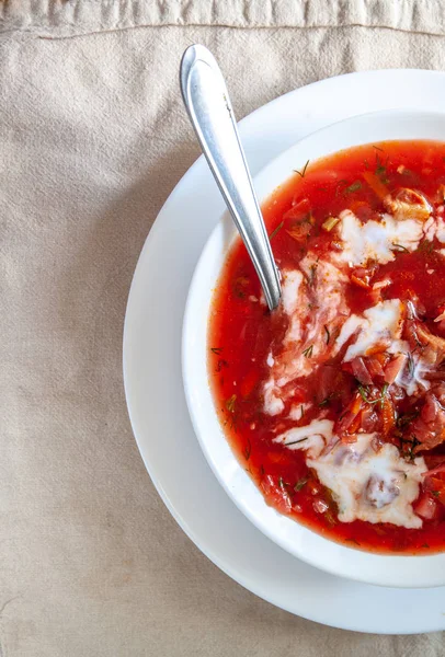 Sopa tradicional de borscht de tomate ucraniano-russo com creme azedo em uma placa branca na mesa. Vista de cima . — Fotografia de Stock