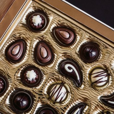 Altın bir kutu da farklı şekillerde Çikolata şekerler, Yukarıdan görüntüleyin. Arka plan.