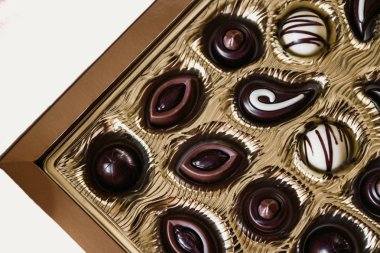 Altın bir kutu da farklı şekillerde Çikolata şekerler,Yukarıdan görüntüleyin. Beyaz bir arka plan üzerinde izole edilmiş. Close.