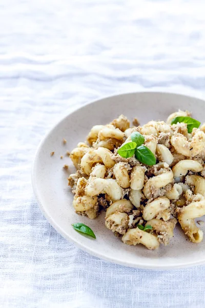 geleneksel sovyet rus makarna çanak, erişte, lacivert makarna, hafif kumaş arka plan üzerinde beyaz bir tabak üzerinde et ile. Yukarıdan Minimalizm Görünümü.