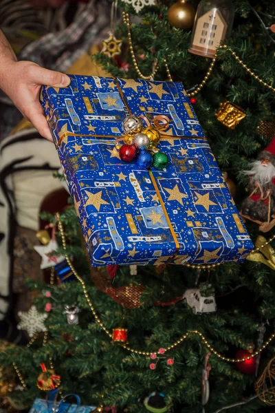 Wrapped gifts under the festively decorated Christmas tree in the hands. Life style — Stock Photo, Image