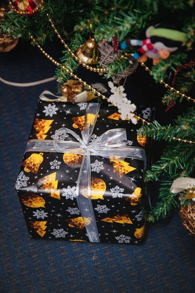 Разнообразие обернутых подарков под празднично украшенной елкой. Стиль жизни — стоковое фото